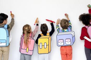 Elèves de dos écrivant sur un mur